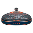 Bovenaanzicht van de Nox AT10 Genius Attack 18K 2025 padelracket, met diamantvormig blad, zwart design met rode details en het witte Nox-logo centraal op het slagoppervlak.