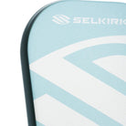 Close-up van het slagoppervlak van de licht blauwe Selkirk AMPED Pro Air Invikta pickleball racket met groot wit Selkirk-logo op het blad.