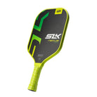 Schuin vooraanzicht van een zwarte pickleball racket met gele rand en geel handvat. Op het slagoppervlak staan groen/gele letters.