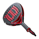 Schuin vooraanzicht: Wilson Bela Pro V3 2025 padelracket in zwart-rood design met hybride vorm.
