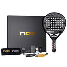 NOX AT Genius LTD Edition 2025 Pack met het druppelvormige racket van 18K carbon, twee zwarte polsbanden met zilveren logo, twee overgrips, twee Smartstrap® banden en een sleutelhanger in de vorm van het racket, exclusief en stijlvol gepresenteerd